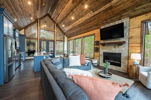 a living room with a couch and a fireplace at Haven Hideaway, New Luxury Cabin w/ hot tub and fire pit in Broken Bow