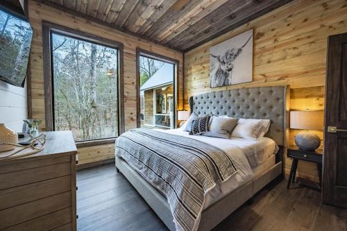 a bedroom with a bed in a log cabin at Haven Hideaway, New Luxury Cabin w/ hot tub and fire pit in Broken Bow