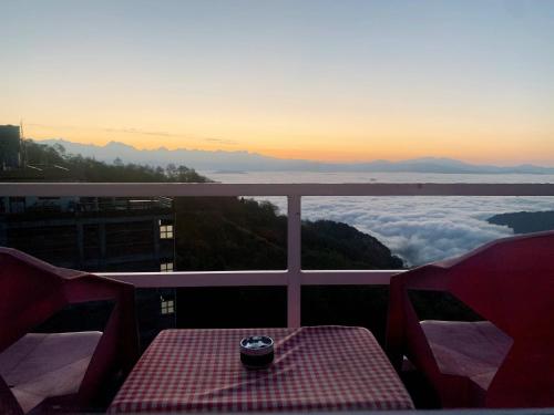 a table on a balcony with a view of the mountains at Mountain Resort in Nagarkot