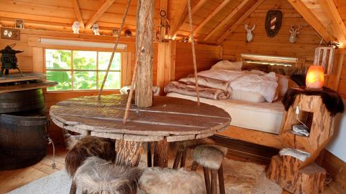 a room with a bed in a log cabin at KOTA Finlandais bien être , les gîtes de l'étang in La Chapelle