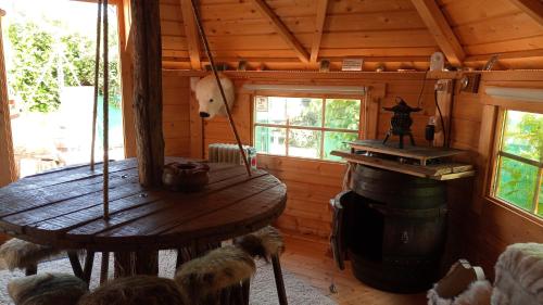 a wooden cabin with a wooden table in a room at KOTA Finlandais bien être , les gîtes de l'étang in La Chapelle