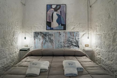 1 dormitorio con 1 cama con 2 almohadas en Casa Vacanze “House on the Left”, en Ceglie Messapica