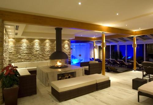 a living room with a couch and a fireplace at Familien- Sportresort BRENNSEEHOF in Feld am See