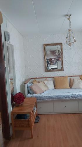 een woonkamer met een bank en een spiegel bij Hineni in Oostvoorne