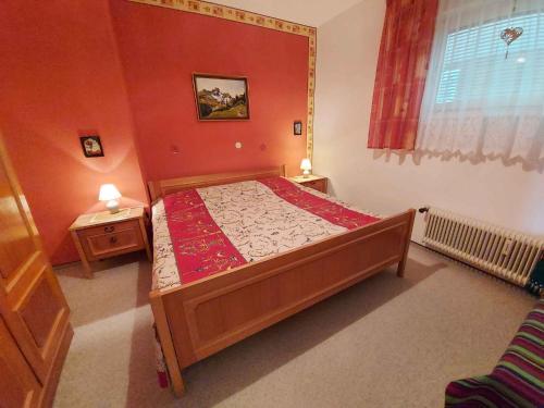 a bedroom with a bed with a red wall at Apartments in Bad Mitterndorf - Steiermark 41117 in Bad Mitterndorf