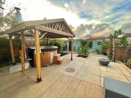 a patio with a hot tub and a gazebo at Alice’s Garden @ Bleak House Farm in York