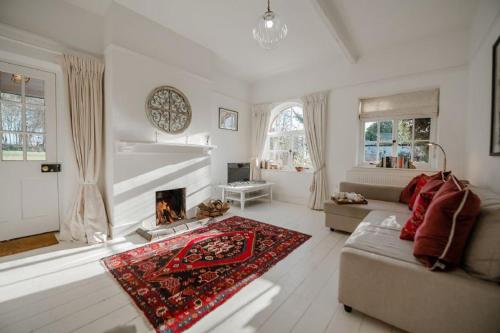 sala de estar con sofá y chimenea en Butley Priory Cottage en Woodbridge