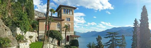 a large building on a hill next to a body of water at Villa Monti in Varenna