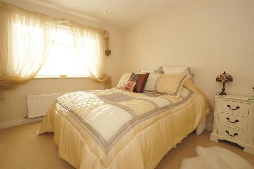 a bedroom with a large bed and a window at Marie-Lyn in Penrhyn Bay