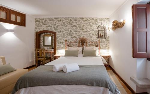 a bedroom with a large bed and a mirror at Casa de S. Thiago de Obidos in Óbidos