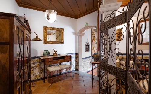 a hallway with a dressing table and a mirror at Casa de S. Thiago de Obidos in Óbidos