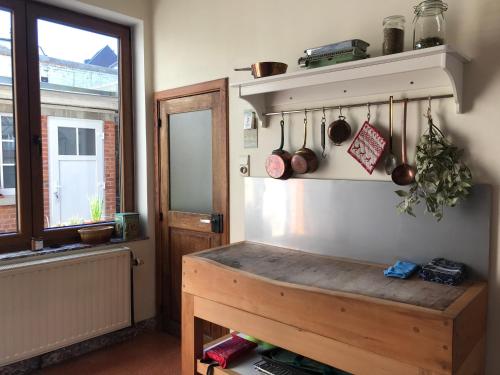 une cuisine avec un banc en bois et une fenêtre dans l'établissement Les colombages, à Dinant