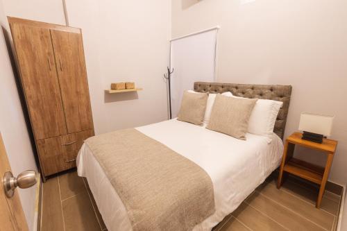 a small bedroom with a bed and a wooden table at Encantador apartamento in Cartagena de Indias