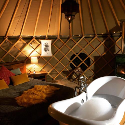 a bathroom with a tub and a sink and a bed at Cerchio Del Desiderio Glamping Retreat in Pescara