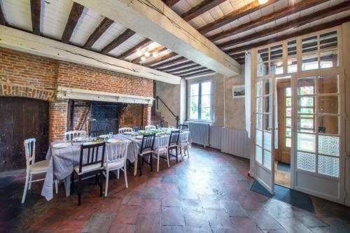 a dining room with a table and chairs in a building at L'Etoile de Forges in Longmesnil