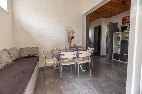 a dining room with a table and chairs and a couch at Domaine de bois joli in Buis-les-Baronnies