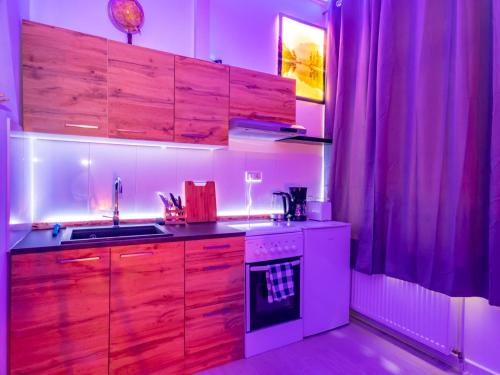 uma cozinha com armários de madeira e um forno de fogão branco em #222 Modernes City Apartment im Herzen von Neuss em Neuss
