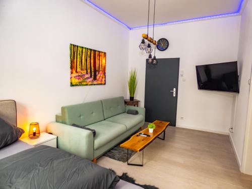 uma sala de estar com um sofá e uma televisão em #222 Modernes City Apartment im Herzen von Neuss em Neuss