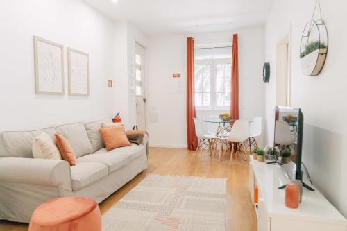 a white living room with a couch and a table at Oporto Yellow Villas in Porto
