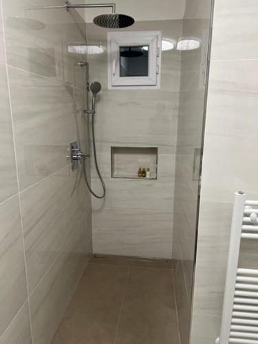 La salle de bains est pourvue d'une douche et d'une télévision murale. dans l'établissement Villa Relax, à Stresa