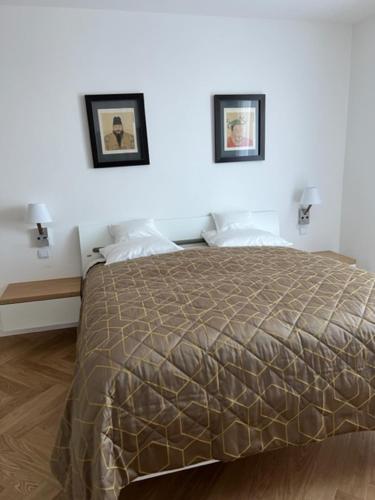 a bedroom with a bed with two pictures on the wall at Villa Relax in Stresa