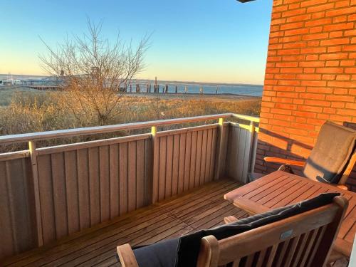 a wooden balcony with a bench and a view of the beach at Haus Seelöwe Wohnung 1 in Wittdün