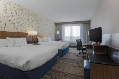 a hotel room with two beds and a flat screen tv at Fairfield Inn & Suites by Marriott Cheyenne Southwest/Downtown Area in Cheyenne