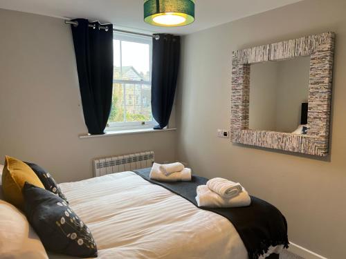 a bedroom with a bed with towels on it at Impeccable 1-Bed Apartment in Ulverston in Ulverston