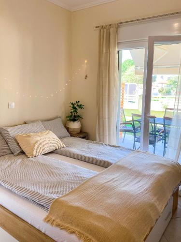 two beds in a bedroom with a balcony at Neroli Apartments in Nikiti