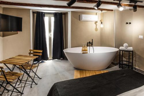 a bathroom with a large tub and a table and chairs at Pendino Luxury Rooms in Naples