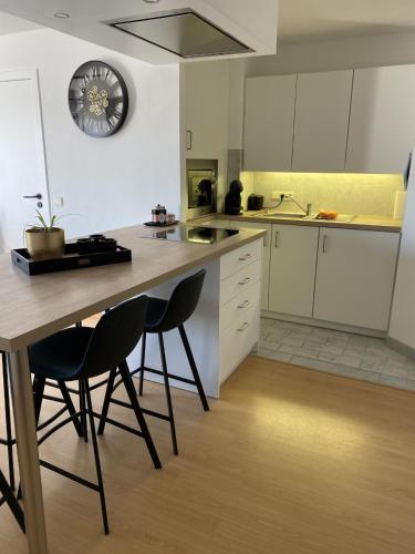 a kitchen with white cabinets and a table and chairs at cosea in Oostduinkerke