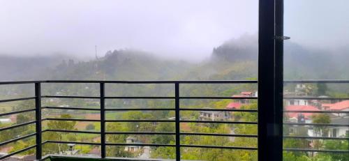a view of a valley from a window with mountains at Foggy Mount View in Bandarawela