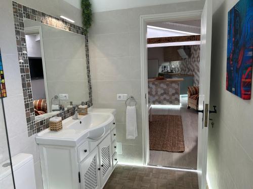 a white bathroom with a sink and a mirror at Casa La Oliva in Garachico