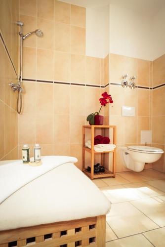 a bathroom with a bed and a tub and a toilet at Zur alten Schule in Burg