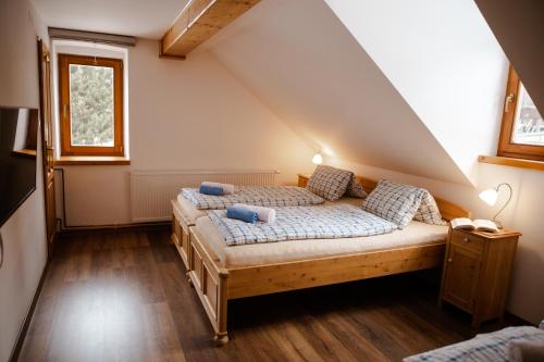 sypialnia z 2 łóżkami na poddaszu w obiekcie Apartmány Bedřichov pod kostelem w mieście Bedřichov