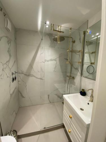 a white bathroom with a shower and a sink at Modernes Apartment an Timmendorfer Promenade, 1. Reihe in Timmendorfer Strand