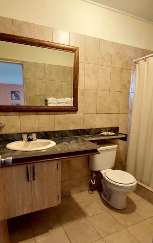 a bathroom with a toilet and a sink and a mirror at Seaview Beach Hotel in Philipsburg