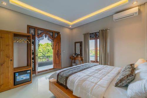 a bedroom with a large bed and a window at The Oni Bisma in Ubud