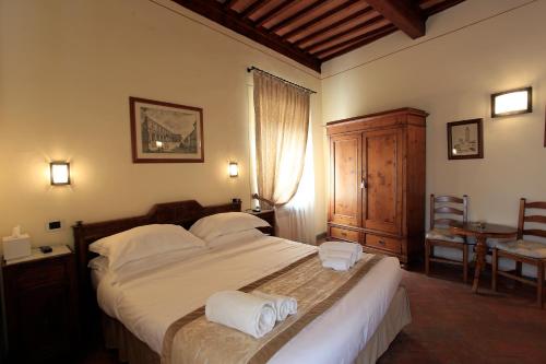1 dormitorio con 1 cama grande y toallas. en Palazzo Mari, en San Gimignano