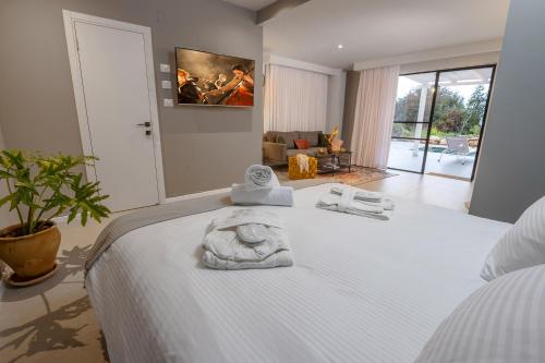 a bedroom with a white bed with towels on it at מרי וסימון - סוויטות יוקרה כפר ורדים in Kefar Weradim