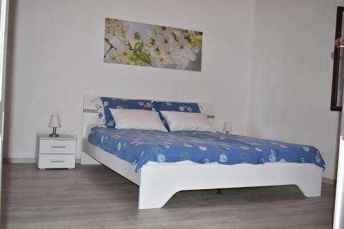 a bedroom with a bed with a blue and white comforter at Apartment Angela in Portorož