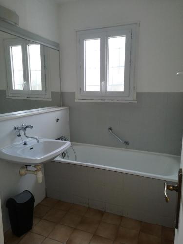 une salle de bain avec un lavabo, une baignoire et un miroir dans l'établissement MAISON A 10MIN DU ZOO DE BEAUVAL, à Noyers-sur-Cher