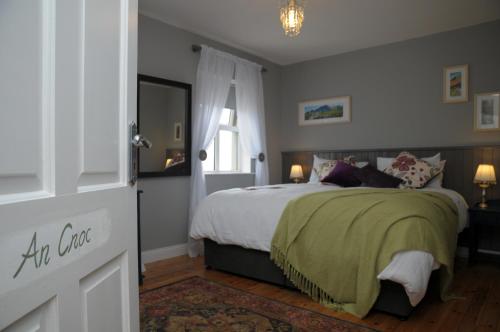 a bedroom with a large bed and a window at An Riasc B&B in Ballydavid