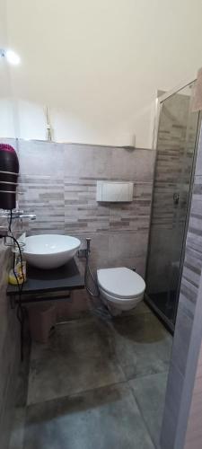 a bathroom with a toilet and a sink and a shower at Elly Guest house in Alghero