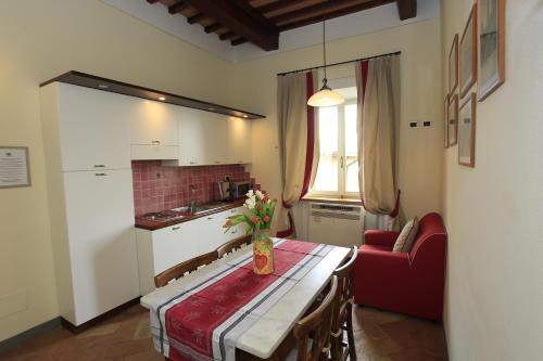 una cocina con una mesa con un jarrón de flores. en Palazzo Mari, en San Gimignano