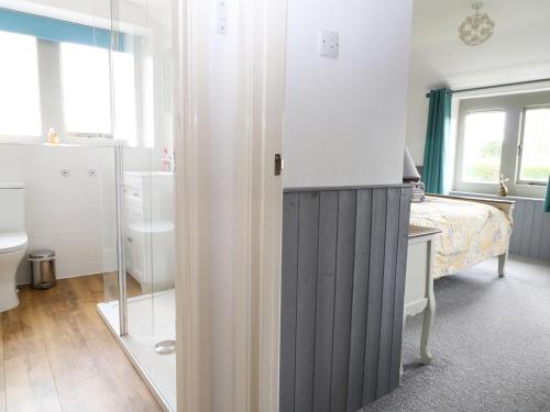 a bedroom with a bed and a sink and a mirror at Honeystone Cottage in Moreton in Marsh