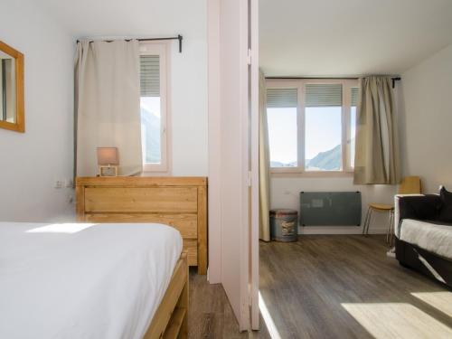 - une chambre avec un lit, un canapé et des fenêtres dans l'établissement Joli appartement à Chamonix avec balcon, WiFi et animaux acceptés - FR-1-343-157, à Chamonix-Mont-Blanc