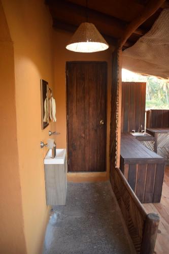 a bathroom with a toilet and a sink and a door at Casa del Mar by Playa Larga in Agua de Correa
