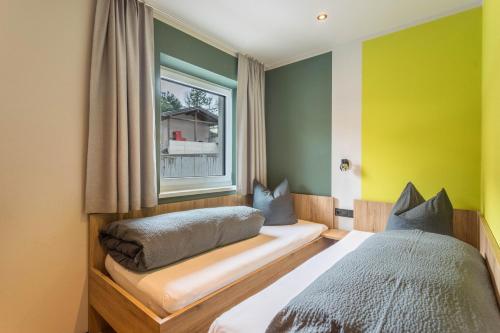 um quarto com 2 camas e uma janela em Luisalle Top 1 em Auffach