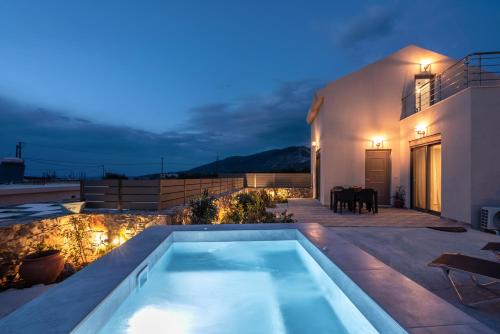 a swimming pool on the roof of a house at night at Pink Sand Villas in Agios Padeleimon